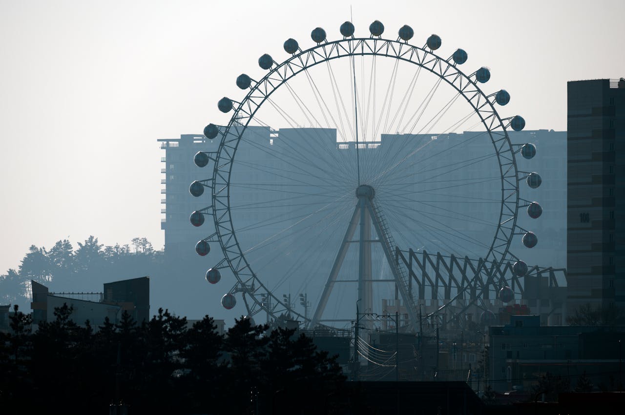 Silhouette of a ferris wheel in Sokcho city, South Korea, against an urban backdrop.