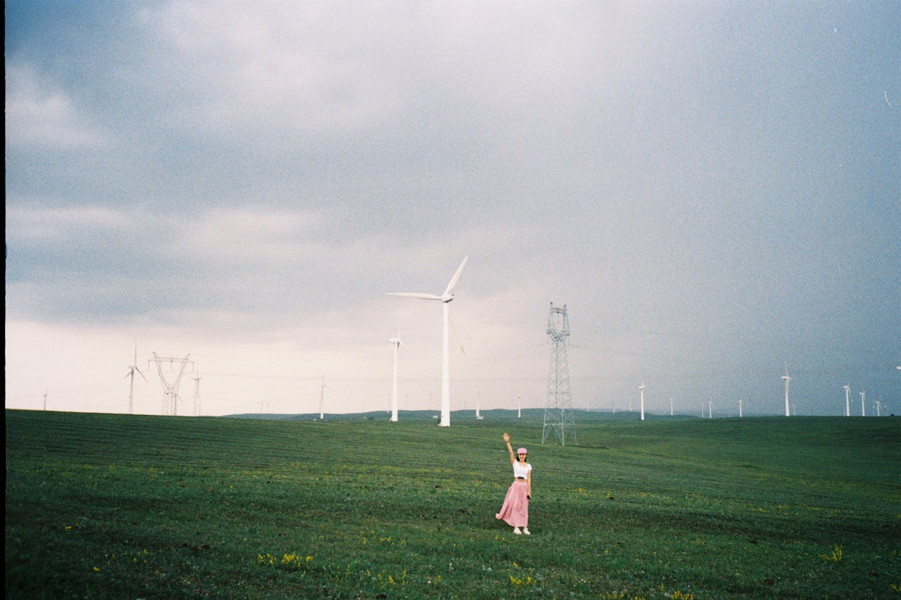 A woman stands in a field of wind turbines in Inner Mongolia, China, capturing the essence of renewable energy.